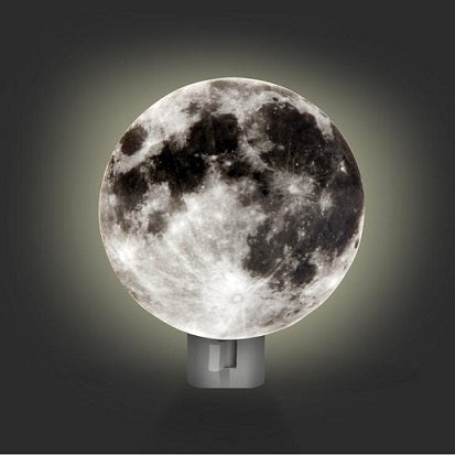 An image of the moon night light in a dark room. The night light is illuminated behind a circular cardboard image of the lunar surface to give the impression that the moon is glowing.