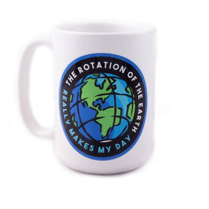A white ceramic mug with a printed cartoon graphic of the Earth spinning. Curved text around the mug reads "The rotation of the Earth really makes my day"